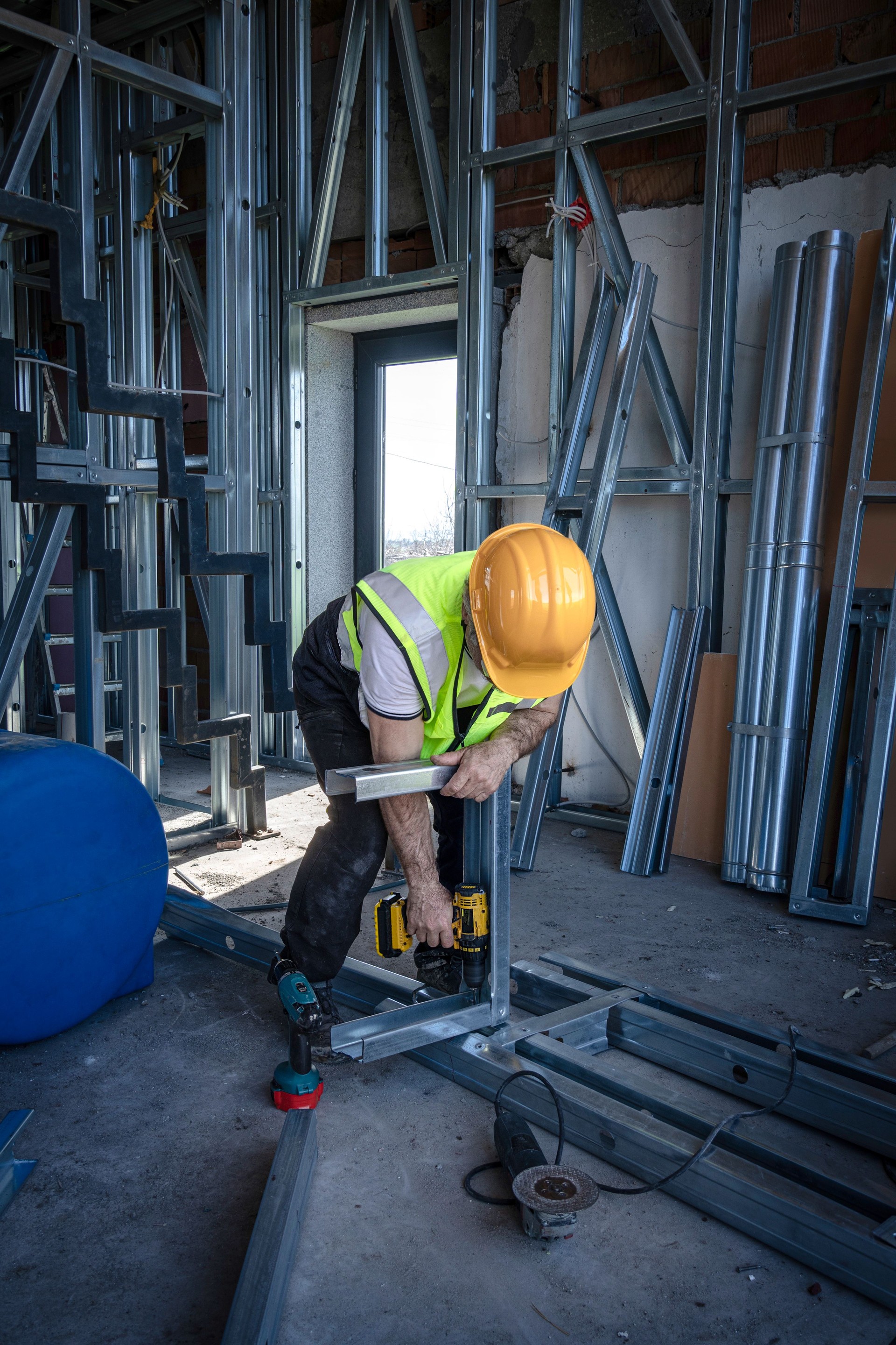 Construction worker using drill indoors.