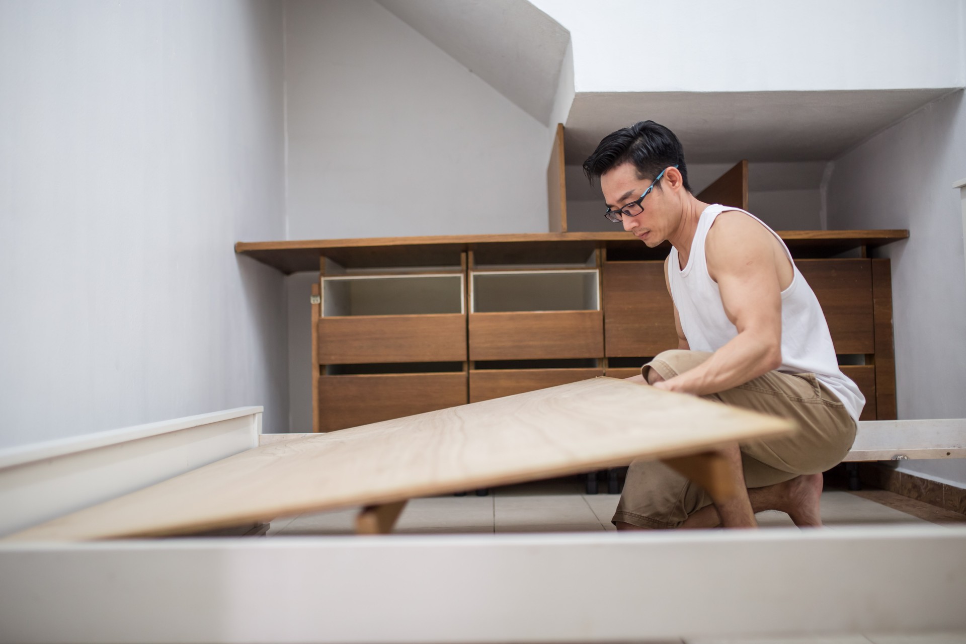 An Asian mature man is installing furniture.